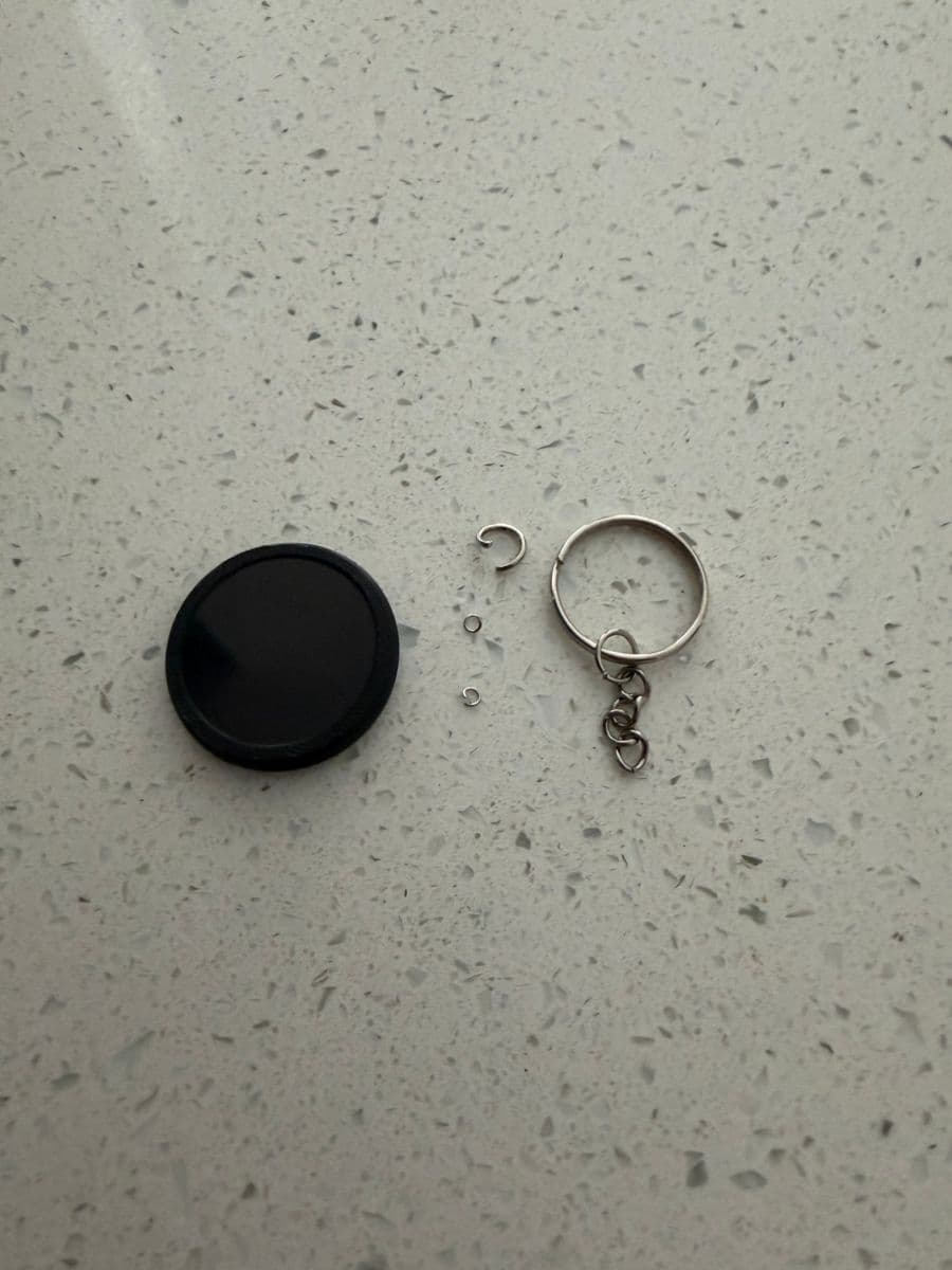 Keychain parts laid out: PixlTag, two small joiner rings, one larger joiner ring and the keychain